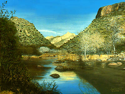 Stream runs through low mountain peaks blue sky